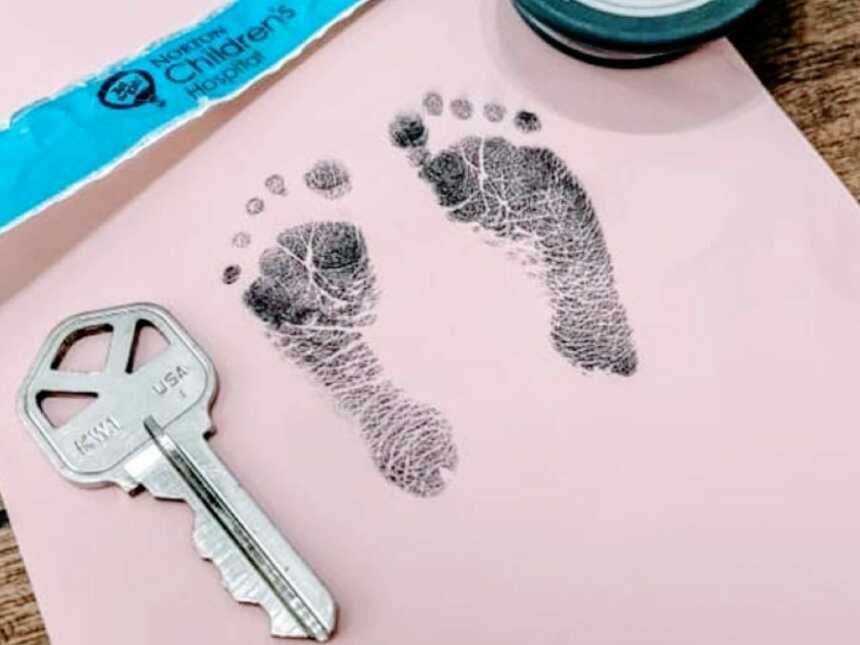 NICU mama snaps a photo of her newborn's feet stamps next to a house key