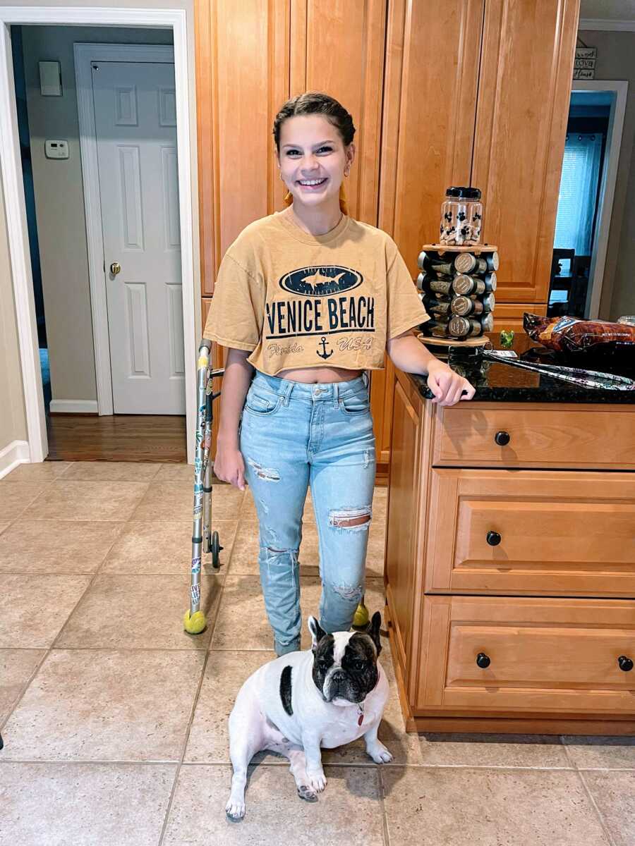 Young teen girl partially paralyzed from a spinal stroke practices walking with a walker in her home