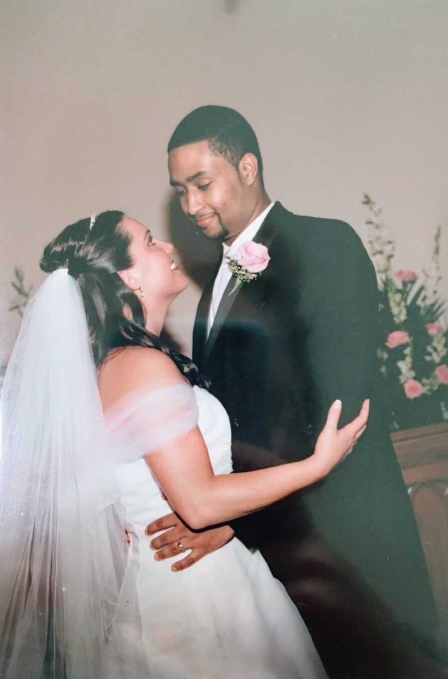 Newlyweds smile at each other while dancing at their wedding reception