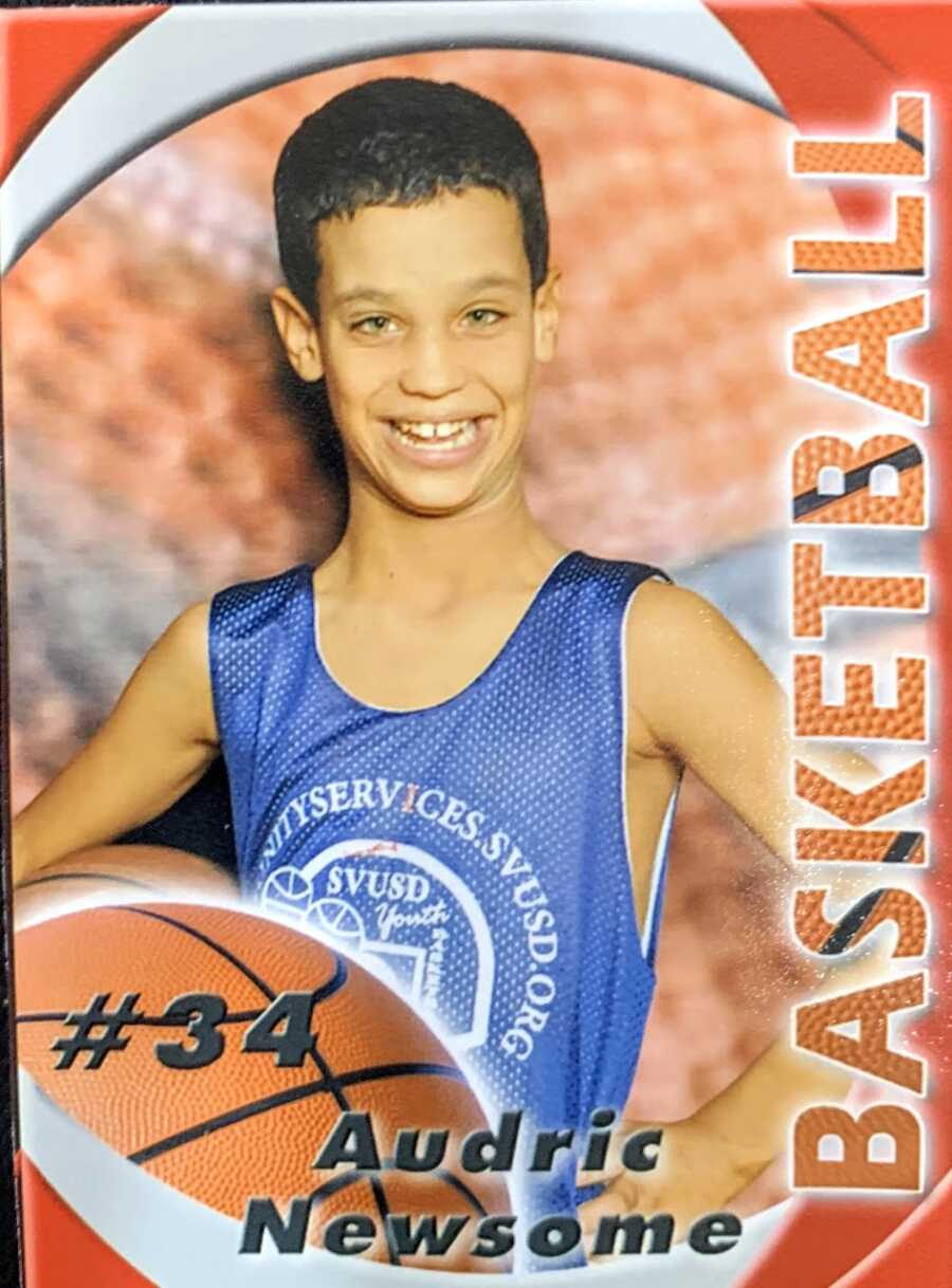 Little boy with Fragile X Syndrome poses for his team photo for the local basketball team