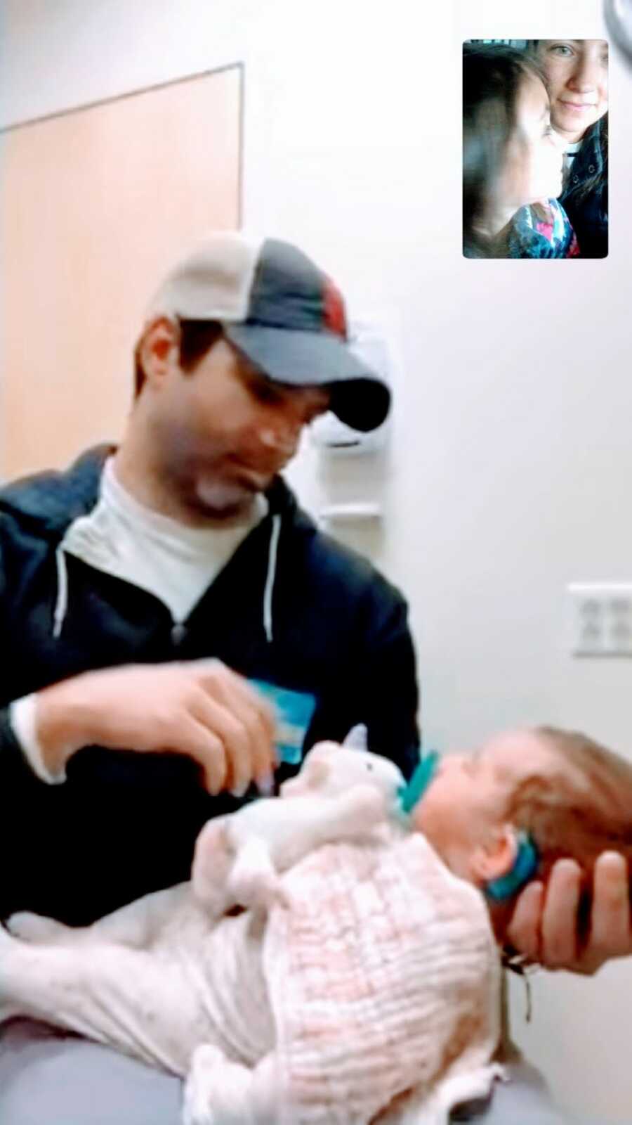 Parents FaceTime each other while one is in the doctor's office with their newborn during Covid getting a hearing screening