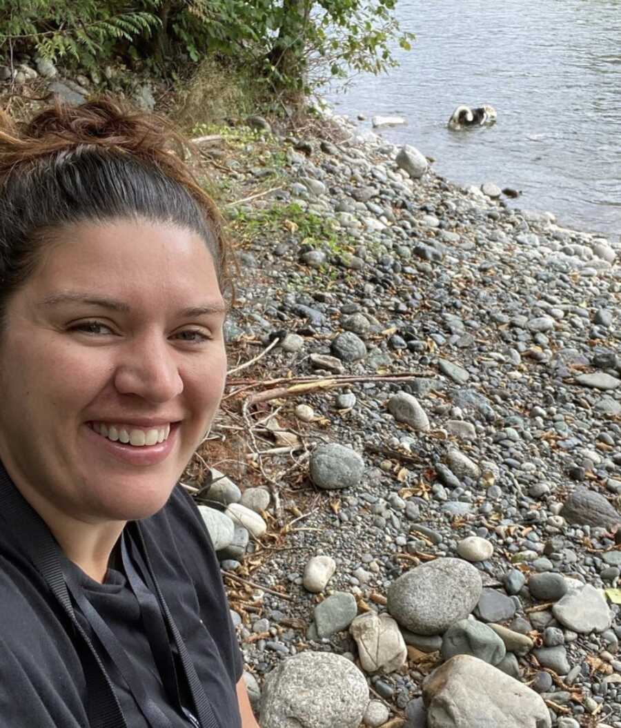 Woman with bipolar sits by lake outside