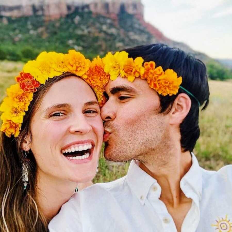 Couple celebrating their wedding anniversary take a cute selfie together while wearing matching flower headbands