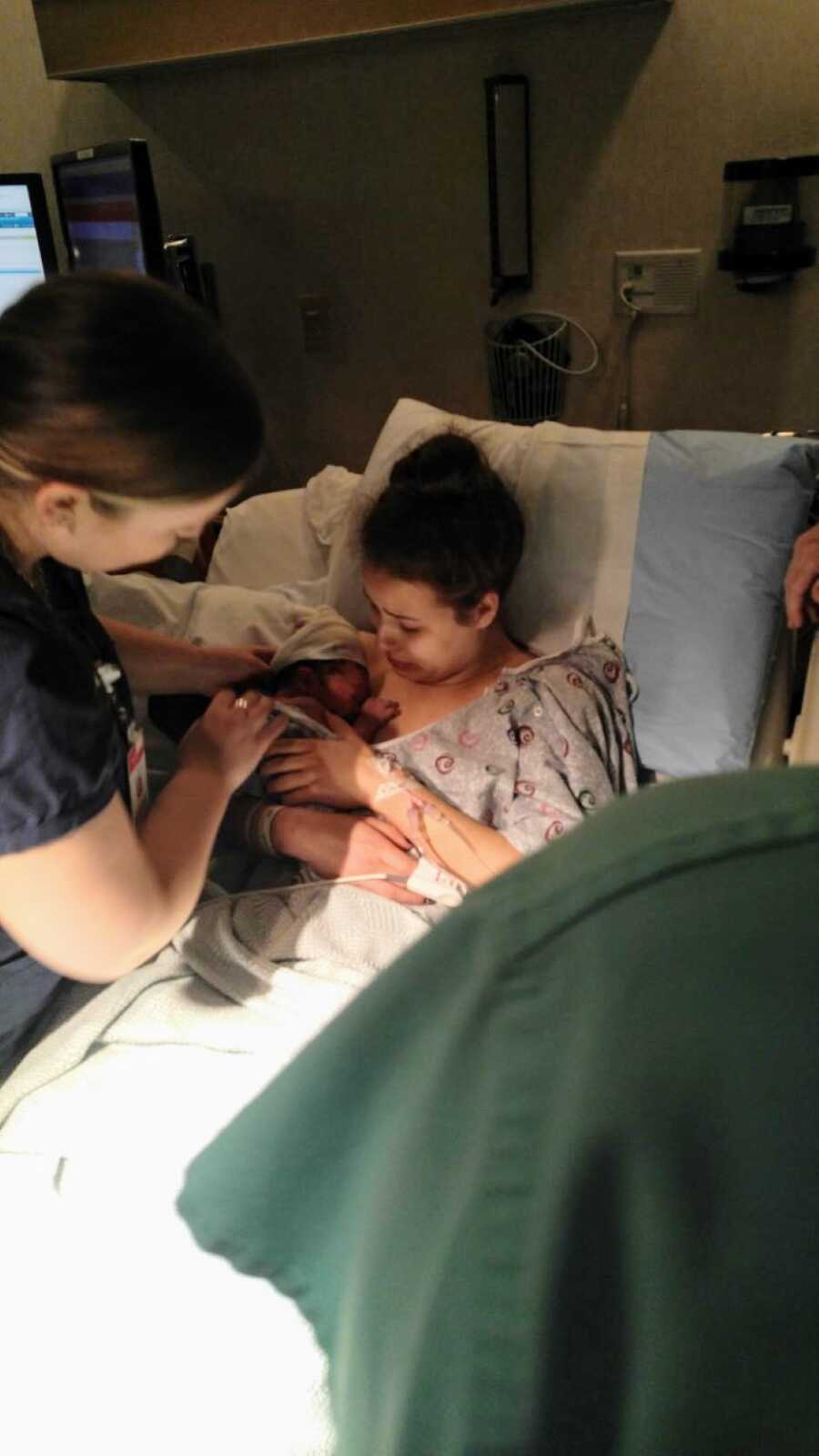 这位18岁的女孩在36小时的分娩后抱着她的新生婴儿哭泣