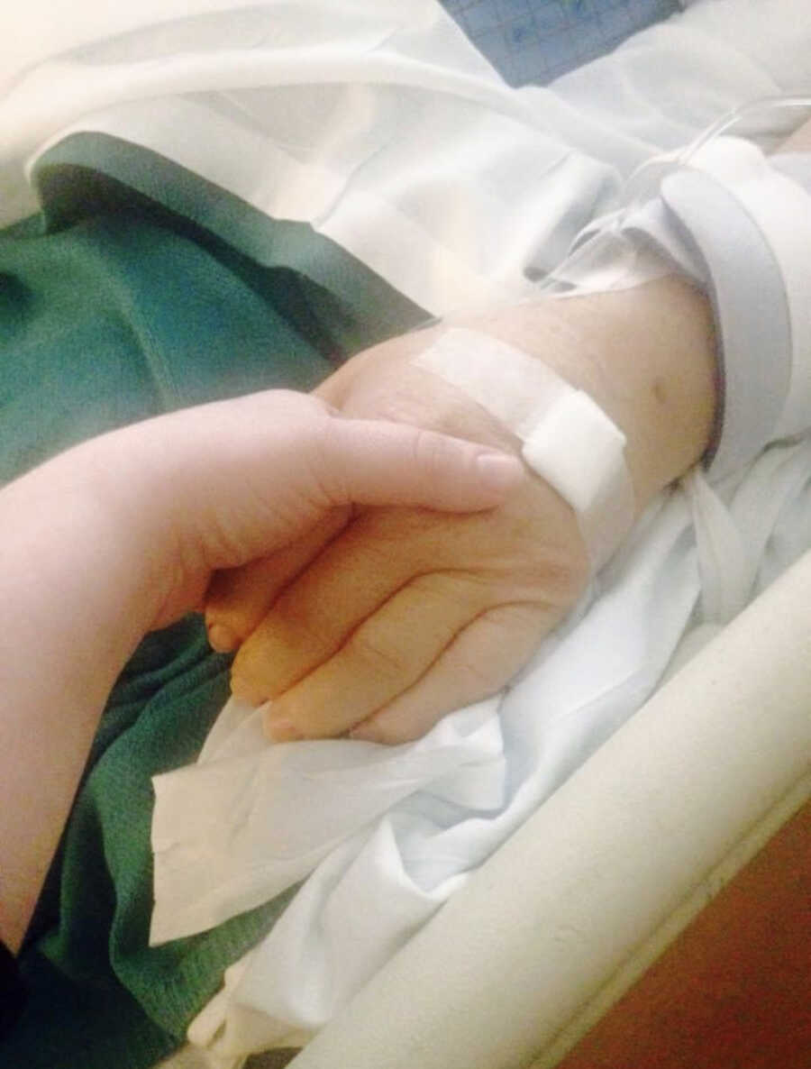 mom holding her dads' hand in the hospital