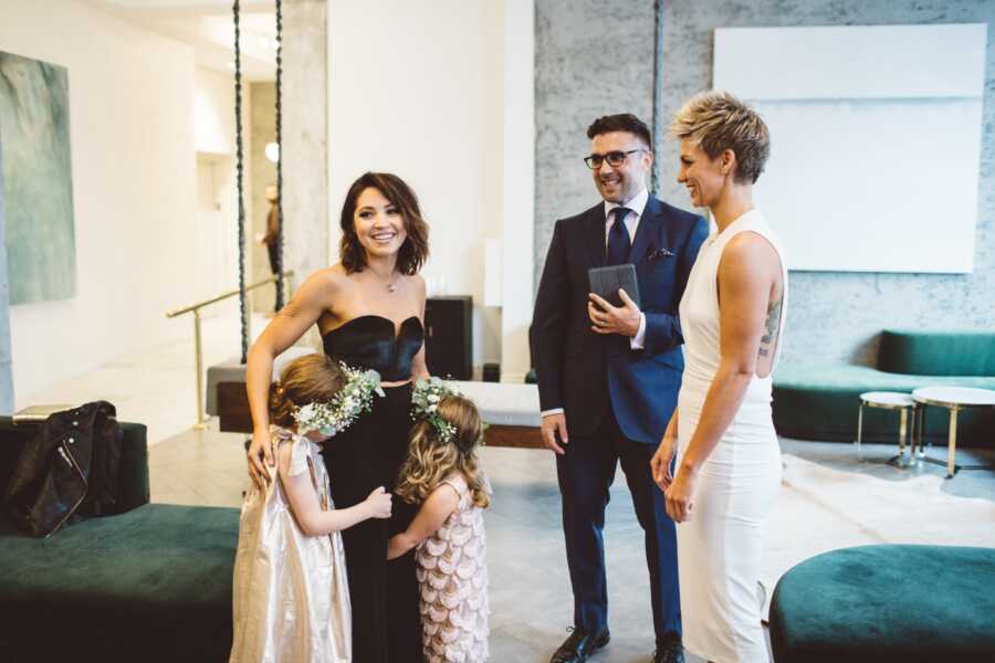 Woman hugs her two daughters while exchanging vows with her new wife