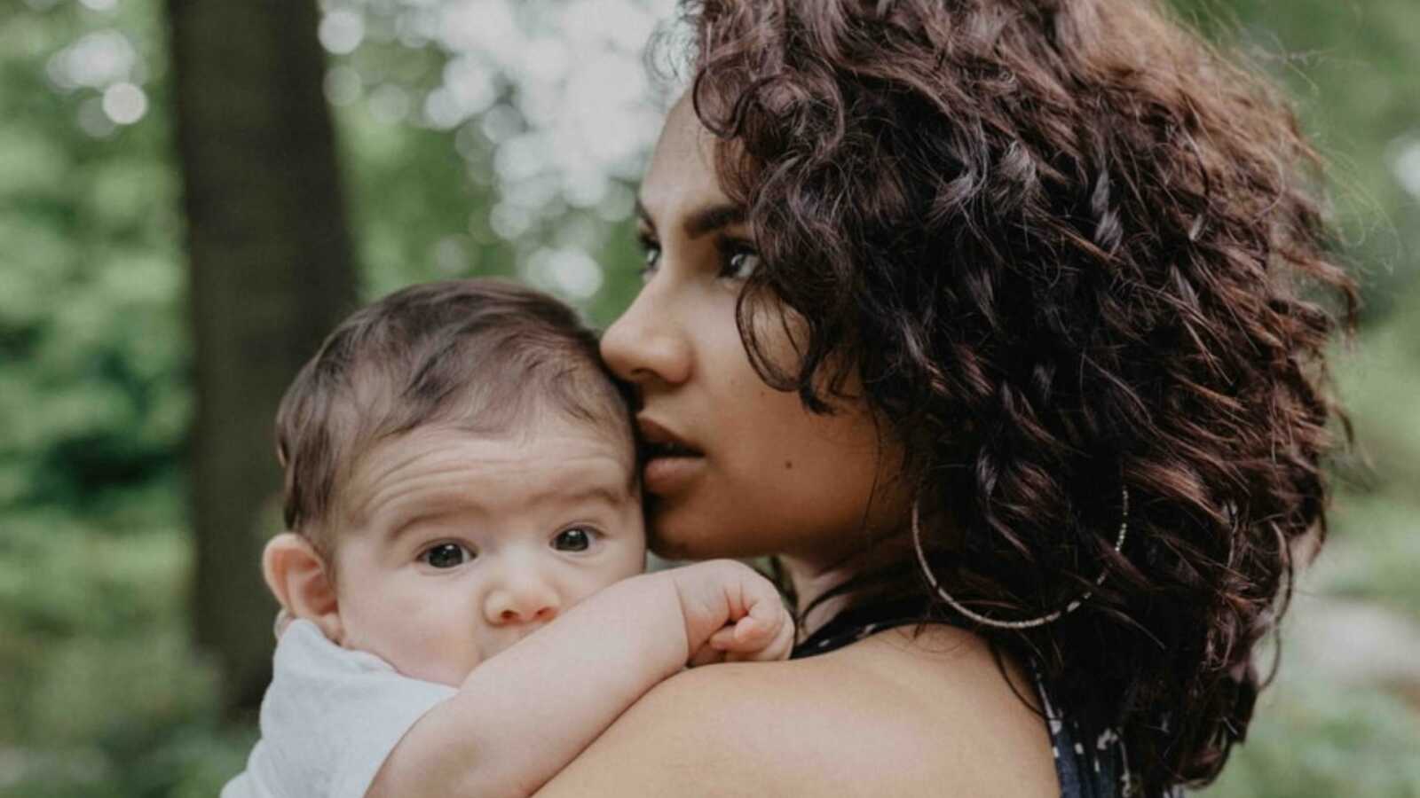 Mom looks off camera while holding her young child