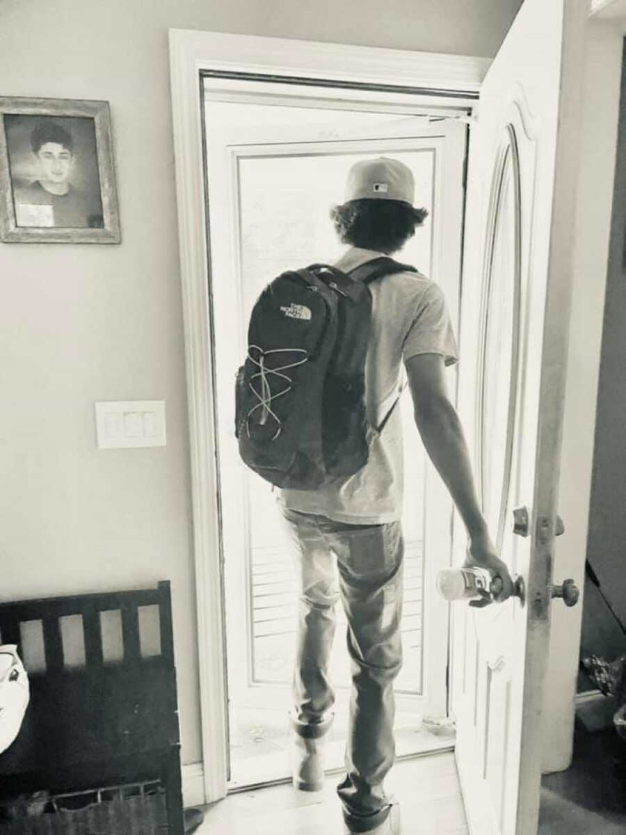 boy walking out of door