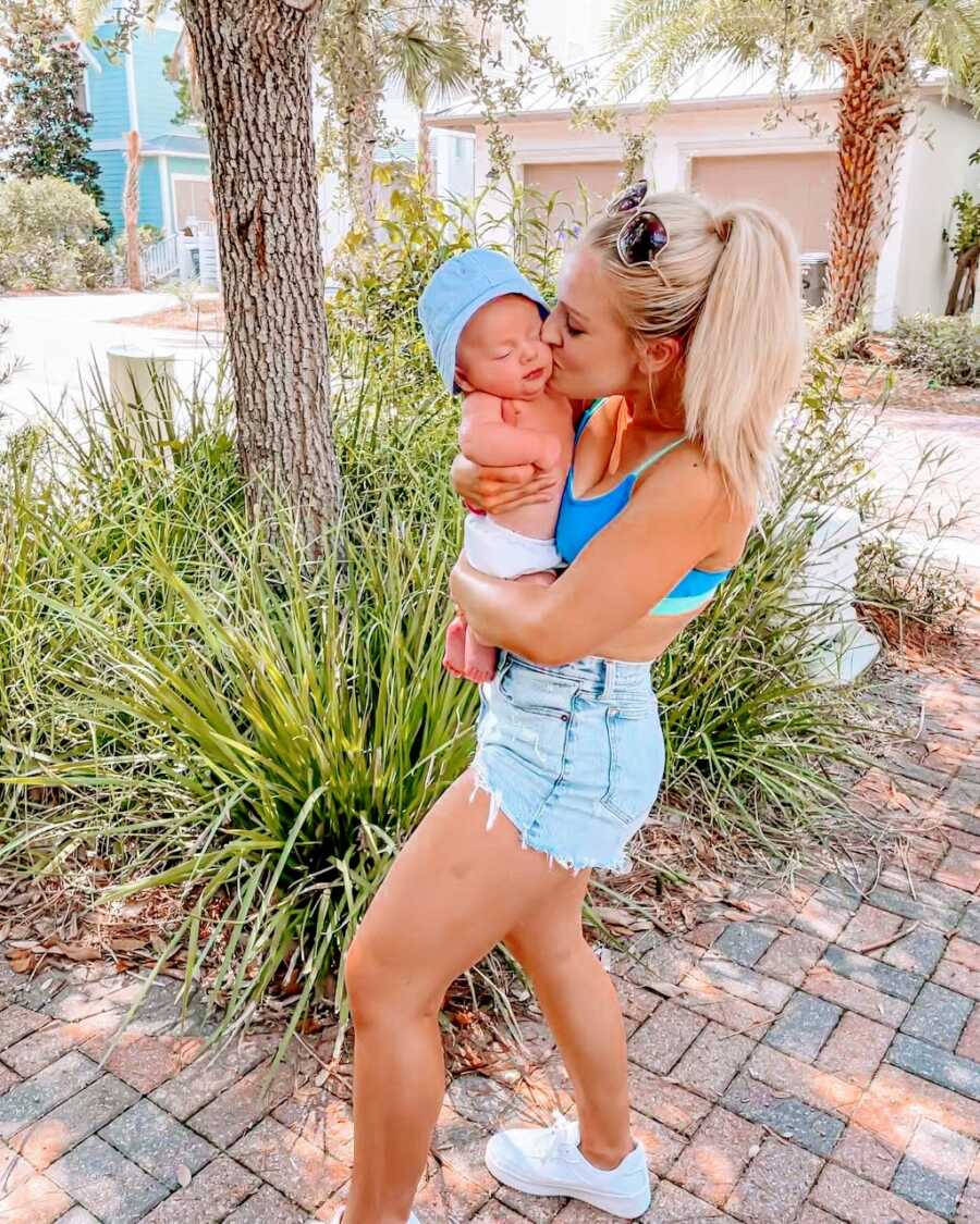 Mom kisses her youngest son on the cheek while enjoying the nice summer weather