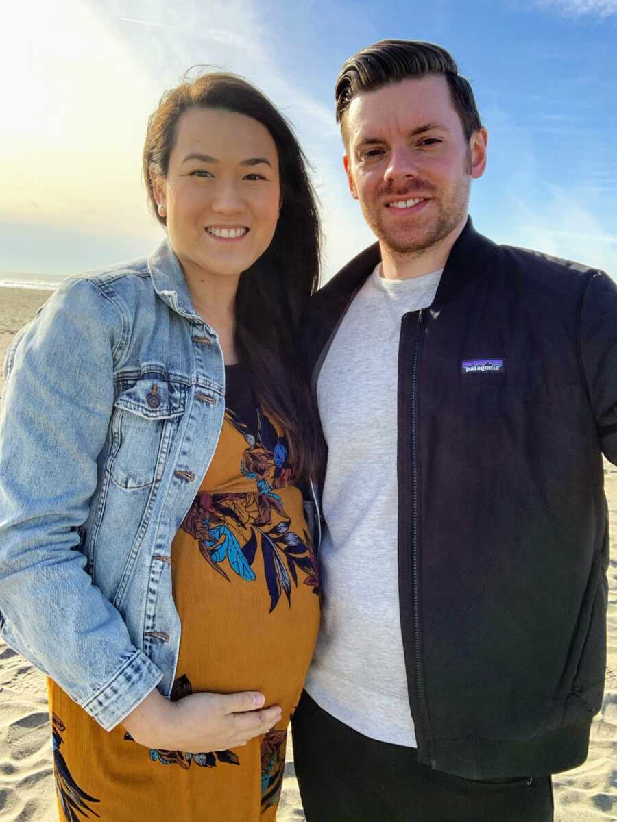 Couple expecting their first child together take maternity photos during golden hour at the beach