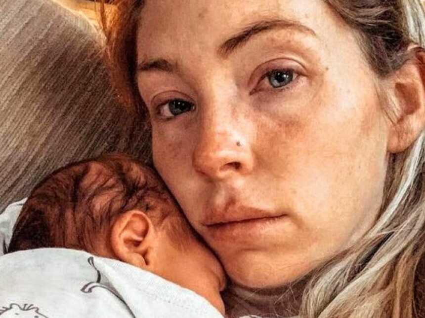 患有产后焦虑症的母亲把刚出生的婴儿抱在沙发上，努力忍住不哭