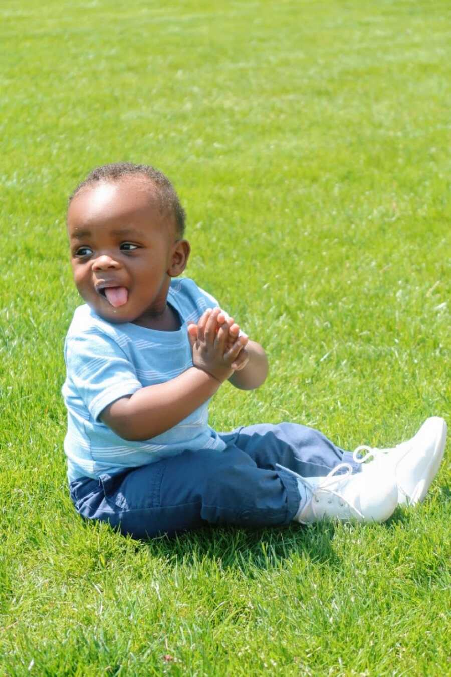 Young single mom takes a photo of her son clapping while enjoying the sunshine