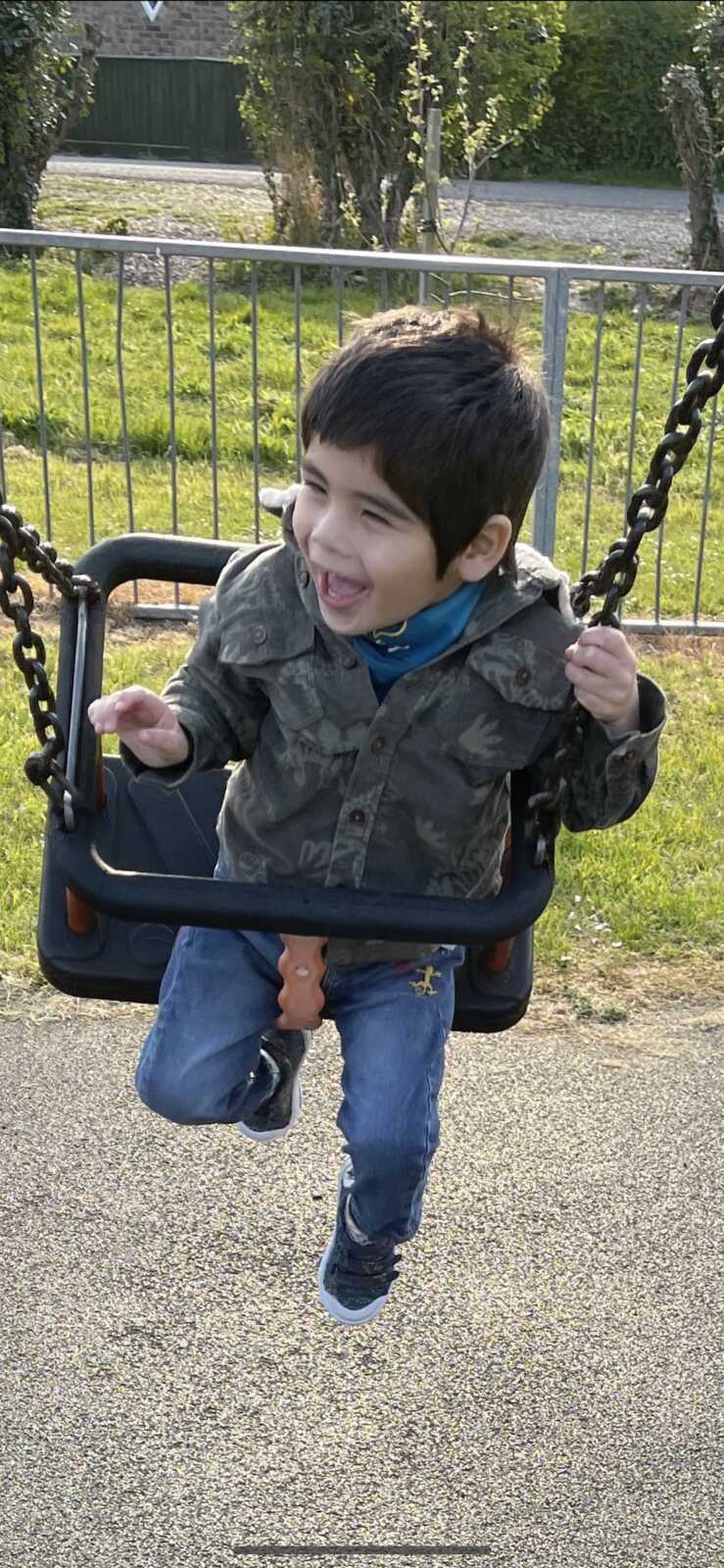 son having fun outside on the swing