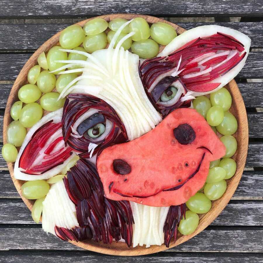 Edible food art fruit platter scene of a smiling cow.
