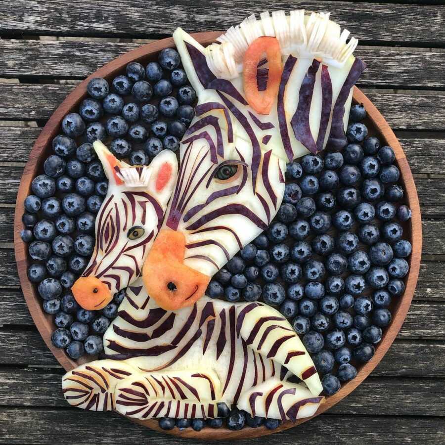 Edible food art fruit platter scene of a zebra with her baby.