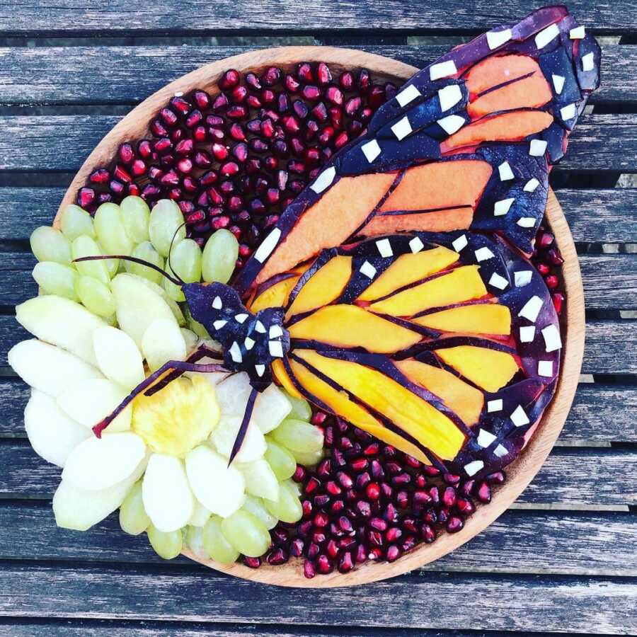 Edible food art fruit platter scene of a monarch butterfly. 