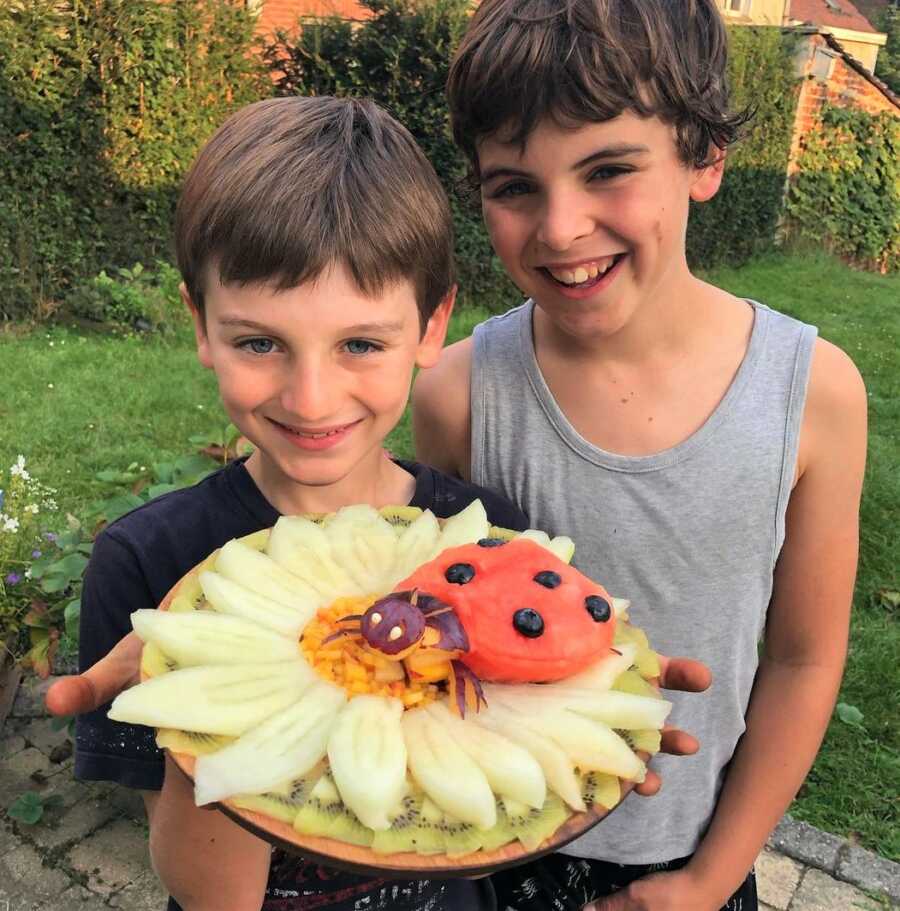 Sarah's boys hold up one of her fruit platter creations. 