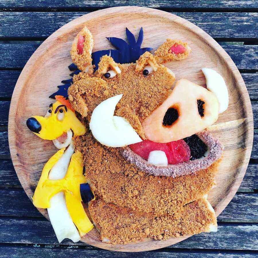 Edible food art fruit platter scene of Pumba and Timon from Disney's The Lion King. 