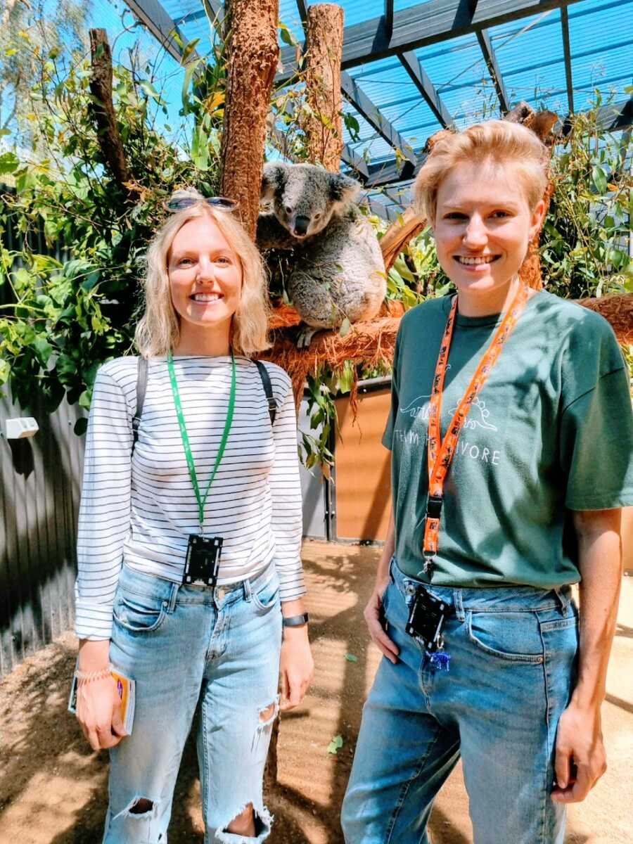 Woman stands with friend near koala