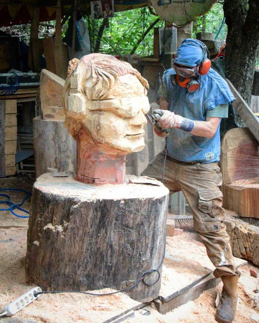 Artistic director, Pit Ruge, carves a giant wood sculpture for the pumpkin exhibition frames.