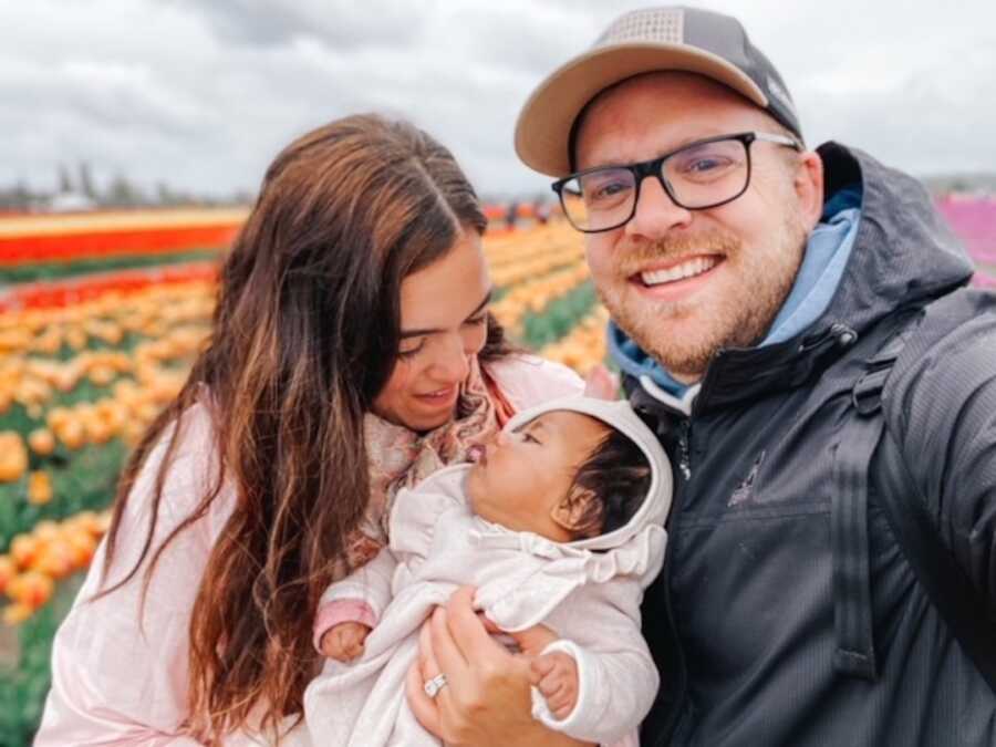 mother and father holding adoptive baby