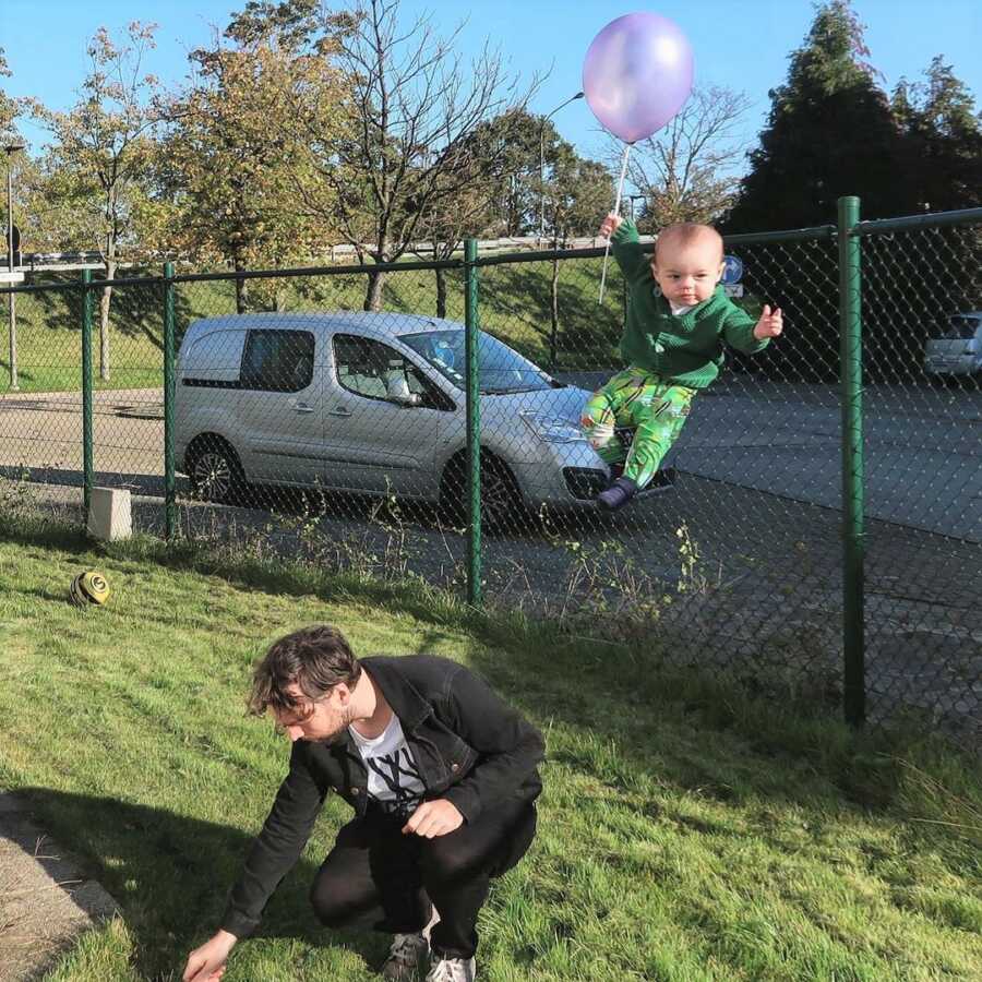 Baby floats away with balloon while dad is distracted picking something up off the ground.