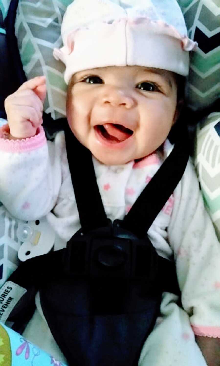 Little girl makes silly face in carseat