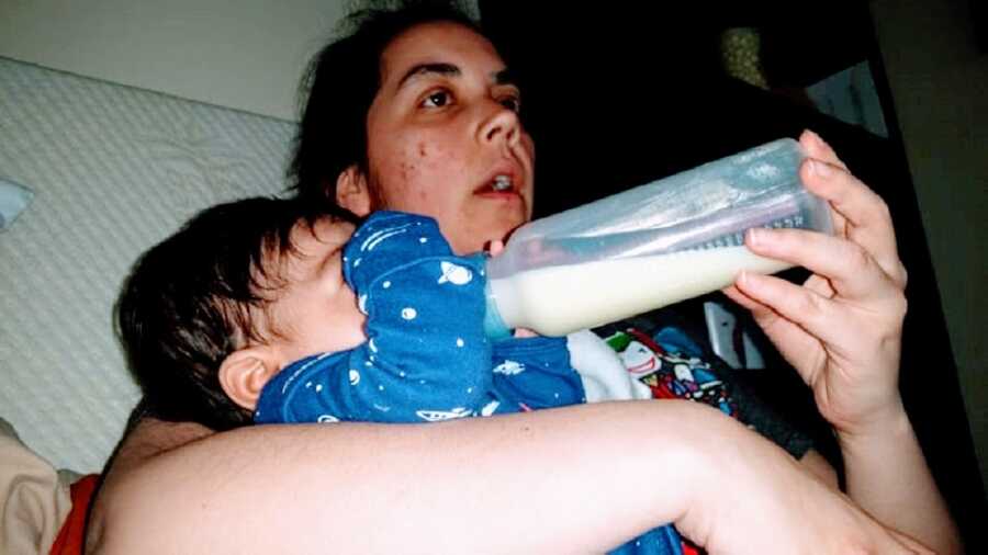 Mother feeding baby girl from bottle