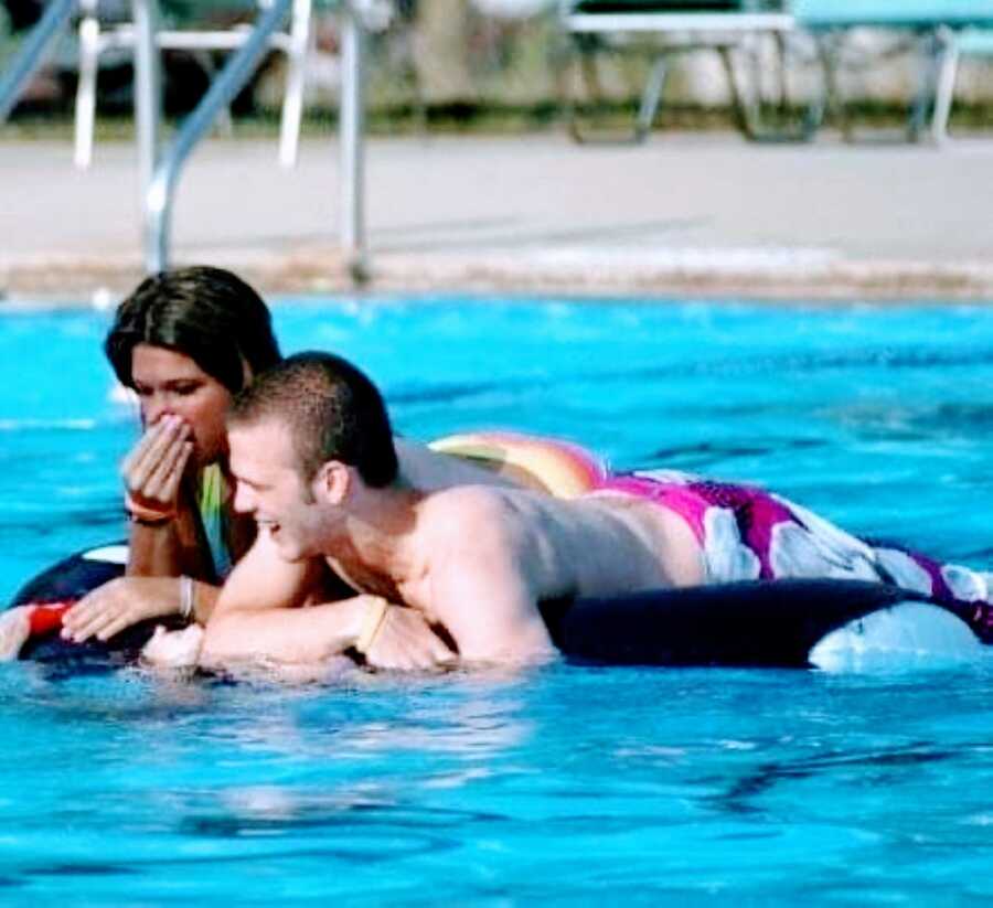 Two teens spend time together on a pool floatie in a community pool