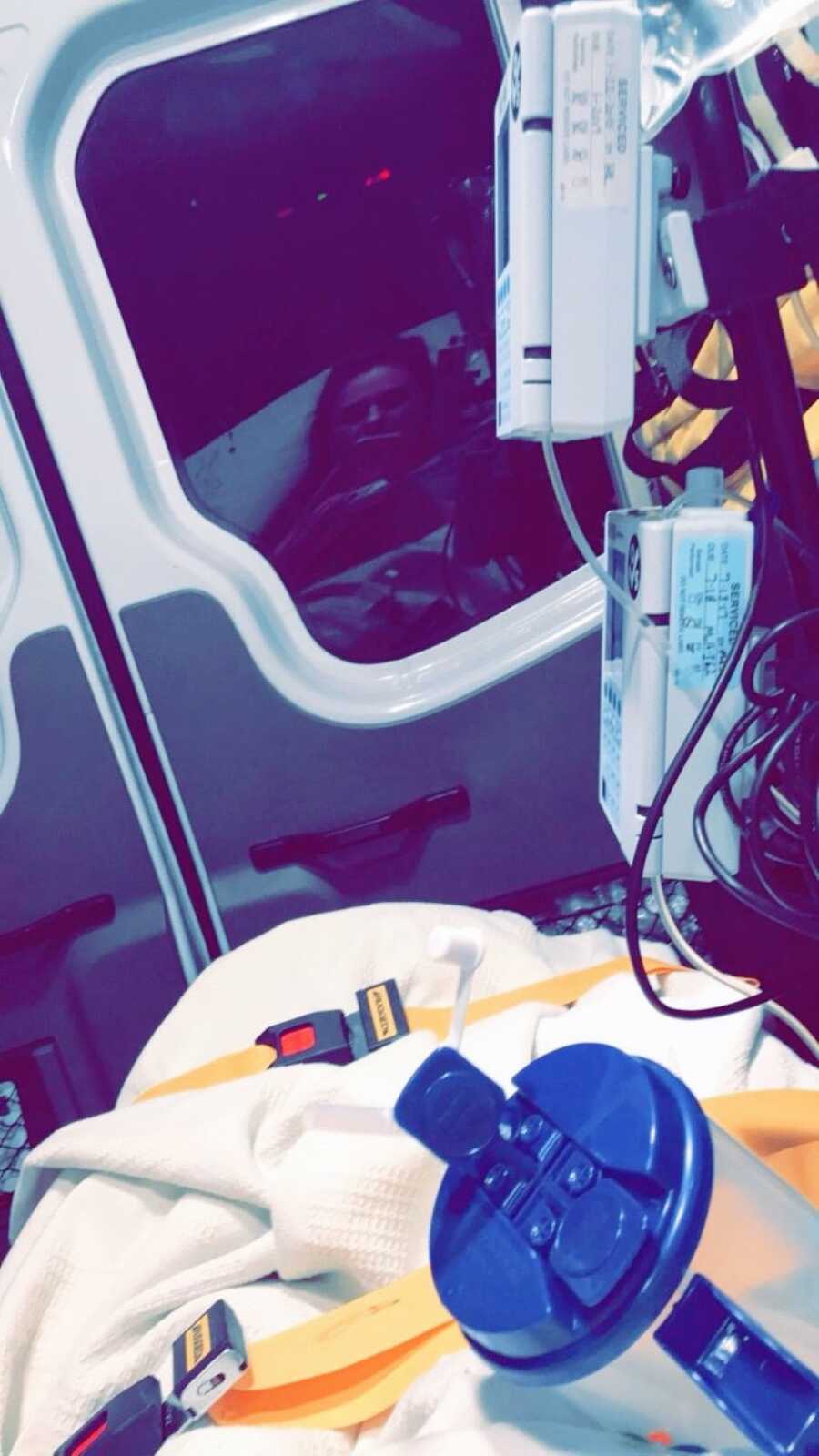 Woman suffering from a miscarriage takes a photo in the back of an ambulance