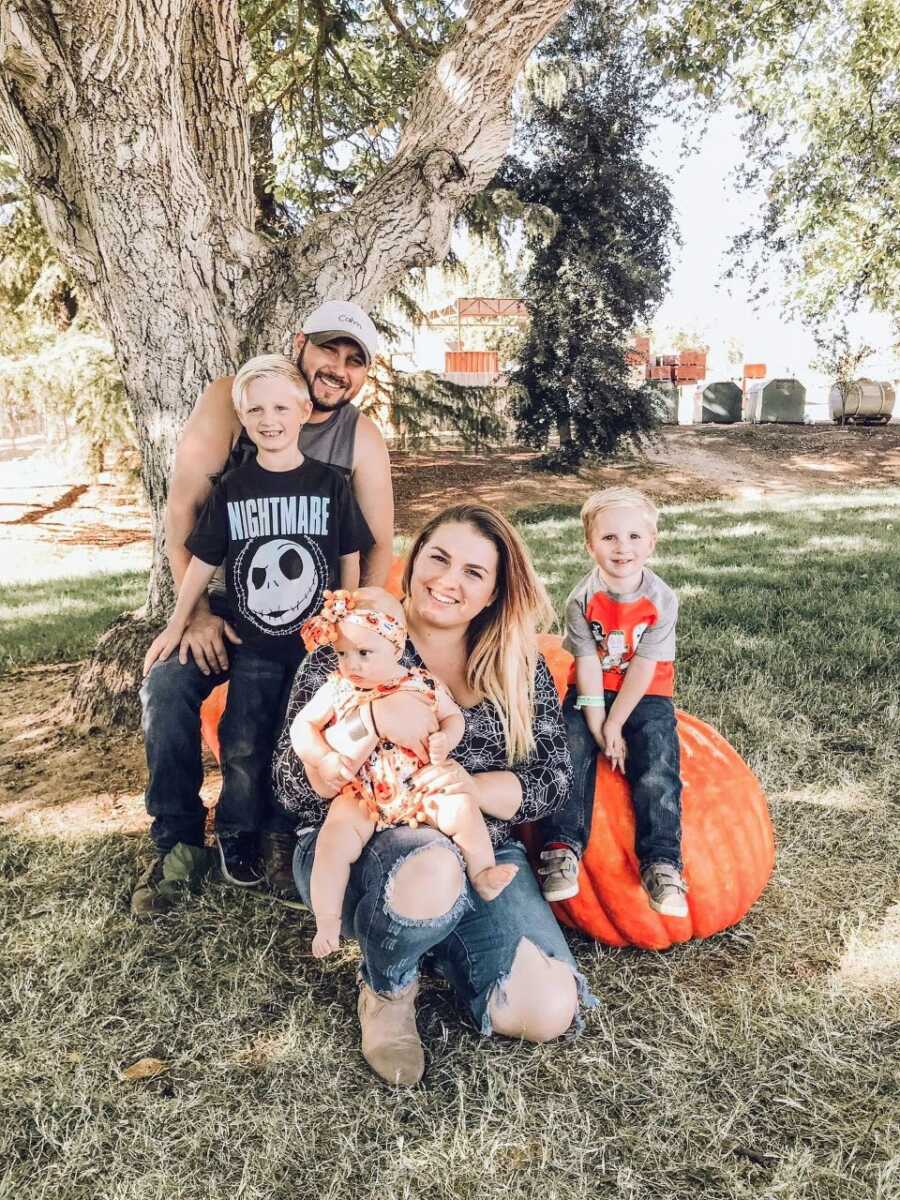 Family of five take photos together with pumpkins in Halloween-themed photos to celebrate the fall season