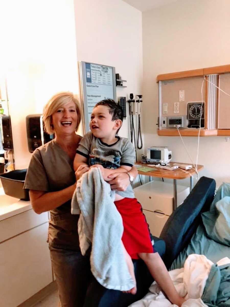 Mom snaps a photo of a nurse holding her son, cheering him up while in the hospital for testing due to seizures
