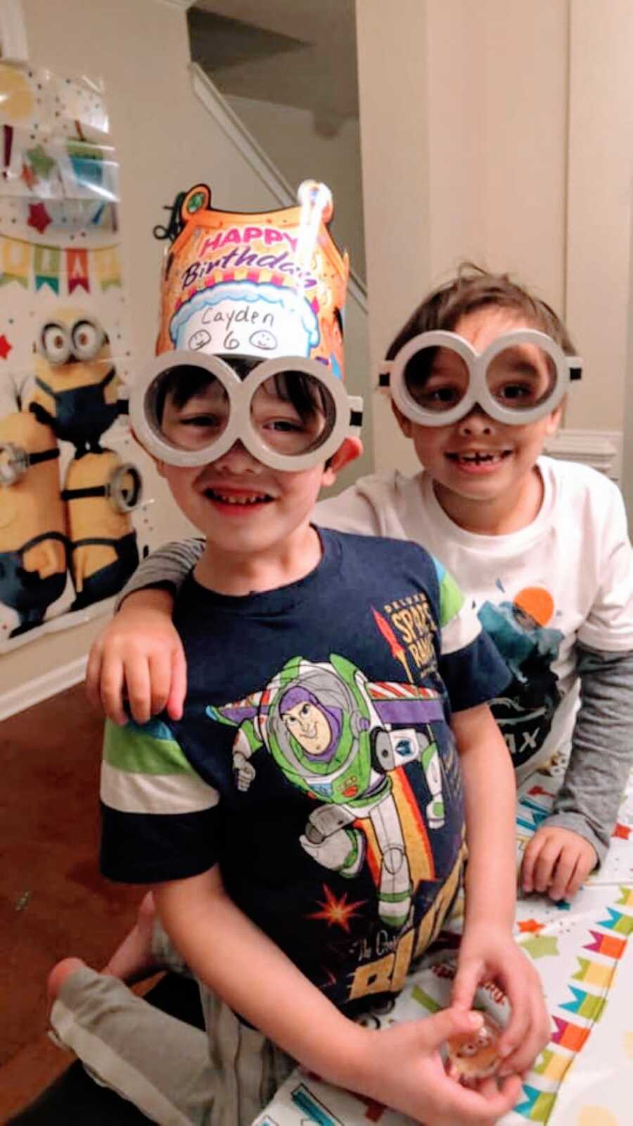 Mom snaps a photo of her two sons having fun at her son's Minion-themed birthday party