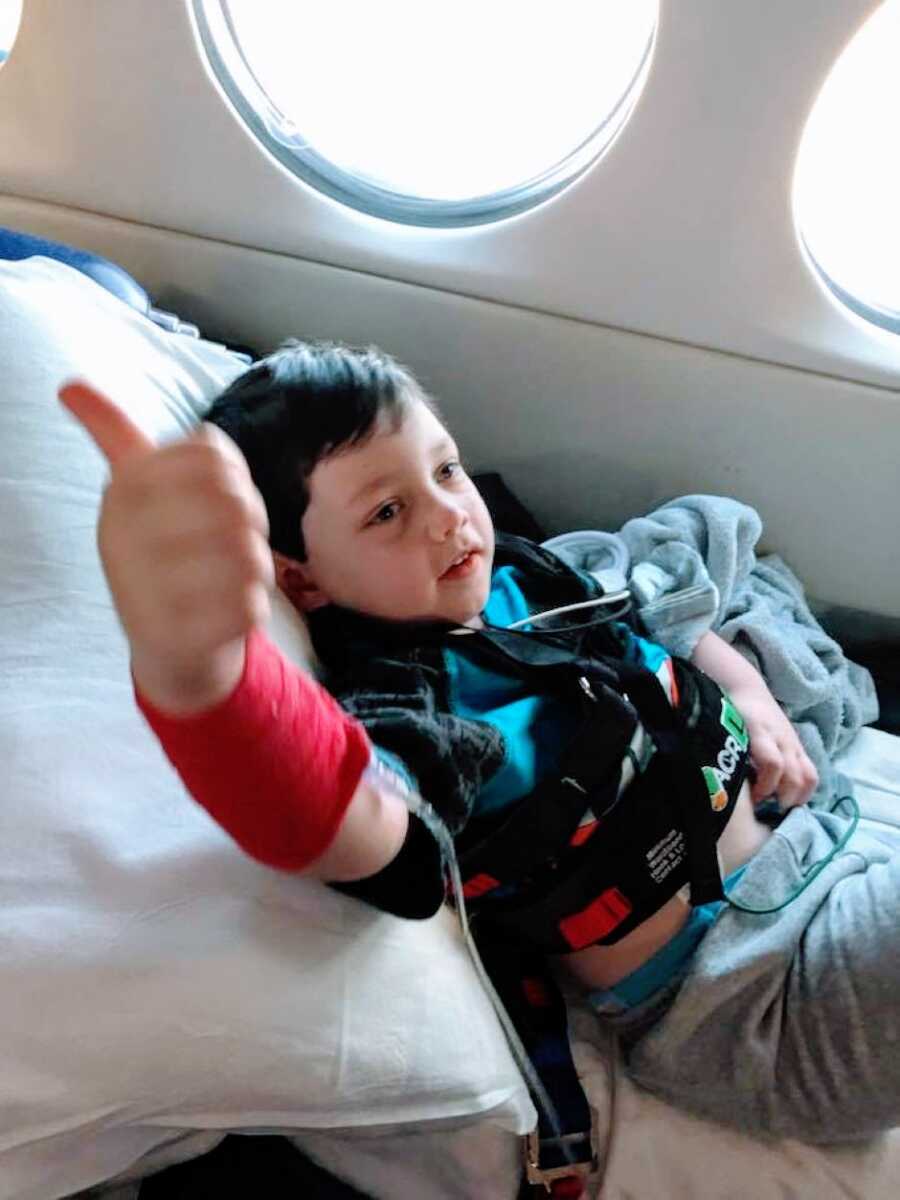 Mom snaps a photo of her son giving her the thumbs up while in a plane on the way to a hospital for his Epilepsy