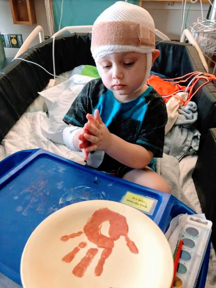 Little boy undergoing EEGs and in-patient therapy practices a craft while in the hospital