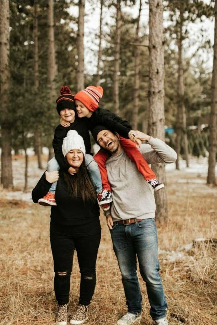 Family of four take a photo together out in the Minnesota cold, all wearing beanies