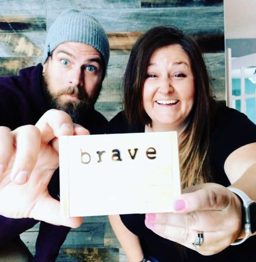 Couple hoping to adopt a son hold up a wooden box with the word "Brave" engraved into it