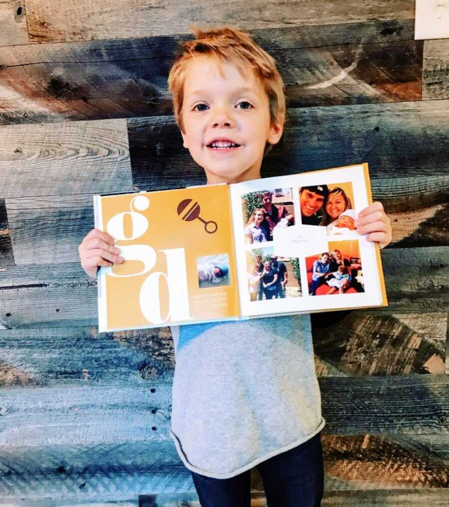 Little boy holds a photobook depicting his adoption and life story