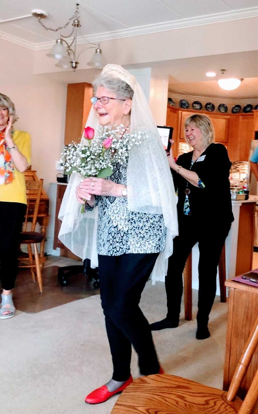 Elderly woman walks out to her husband on their 75th wedding anniversary while wearing her original veil and holding a bouquet of flowers