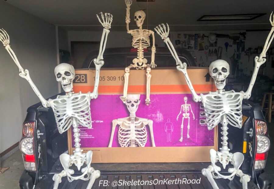 Couple take a photo with their fake skeleton family welcoming the infamous 12-foot skeleton to the crew