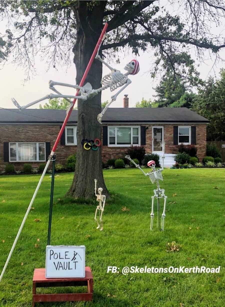 Couple use Halloween skeleton decorations to create a pole vaulting yard scene for the Summer Olympics