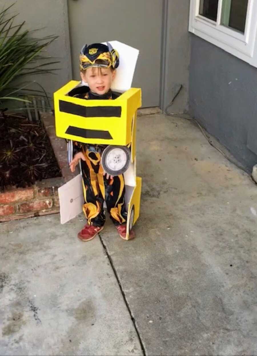 Little boy poses for a photo in a homemade Transformers Bumblebee costume for Halloween