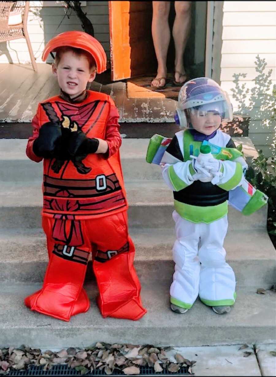 Mom snaps a photo of two of her sons in Halloween costumes before trick or treating, one a Lego ninja and the other Buzz Lightyear