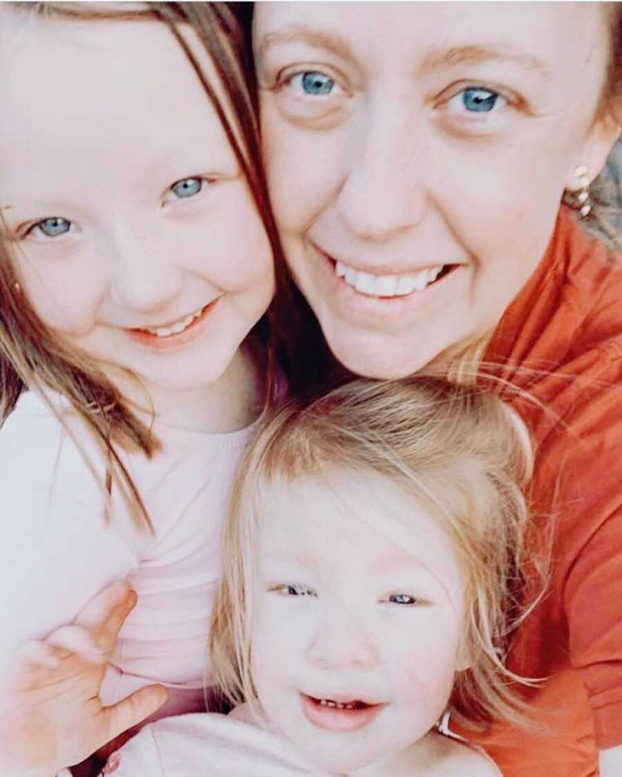 Girl mom takes a selfie with her two daughters, showing how much they all look alike