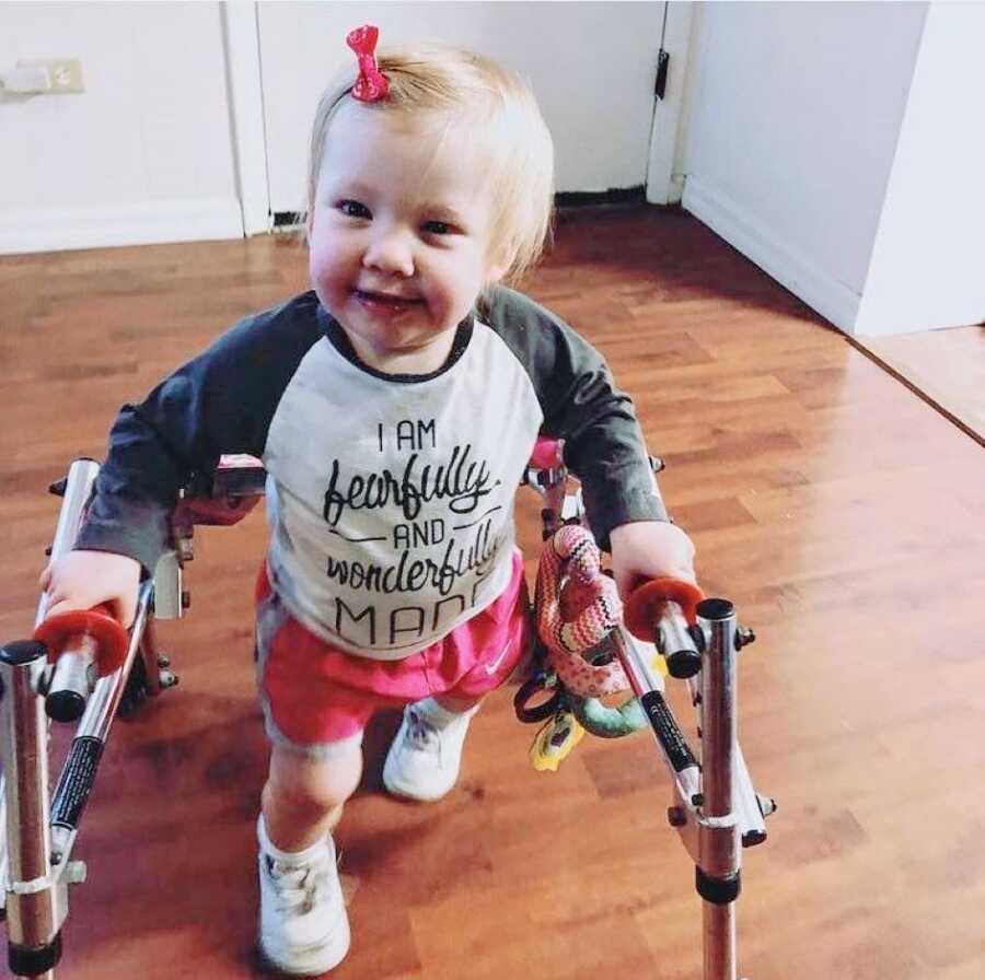 Little girl with rare Coffin-Siris Syndrome practices walking with a walker