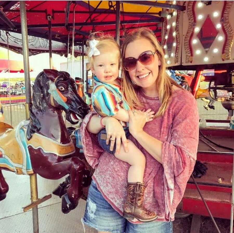 Mom to two girls takes a photo with her youngest daughter who has Coffin-Siris Syndrome at the local fair