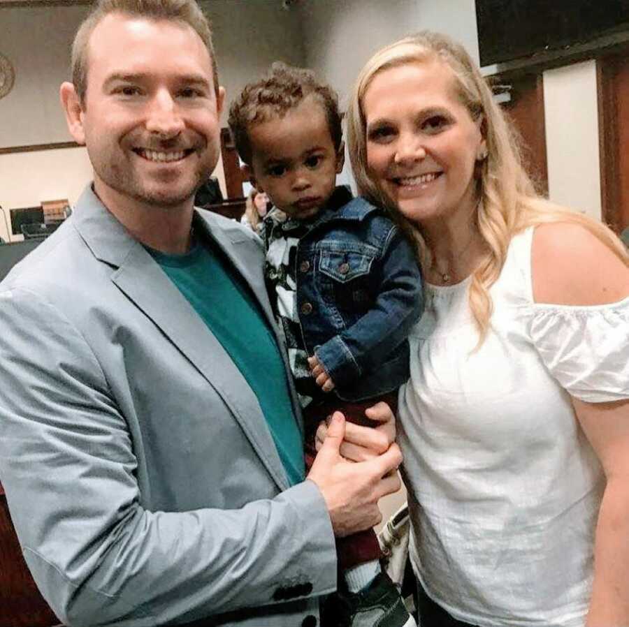 Adopted parents hold their youngest son in the court room on his official adoption day