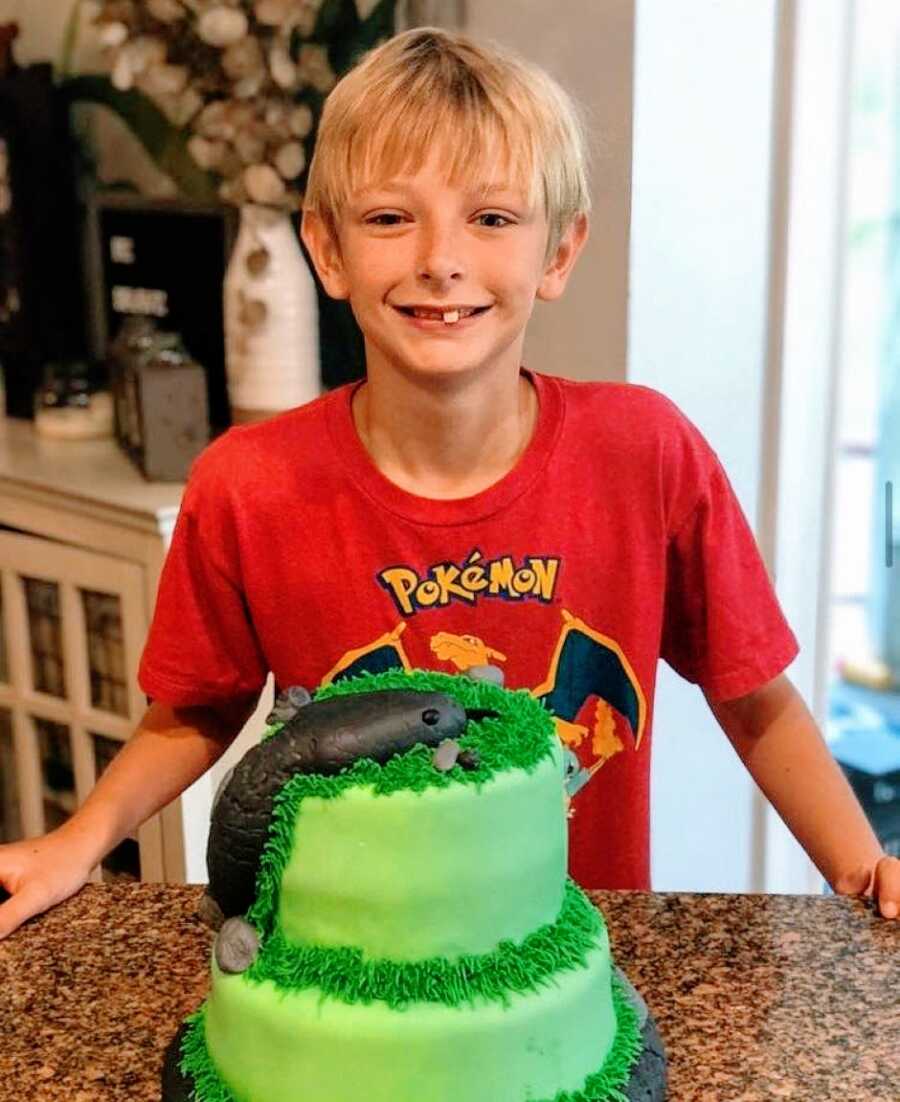 7岁的妈妈拍了一张她的一个收养儿子，生日那天用蛇蛋糕微笑着