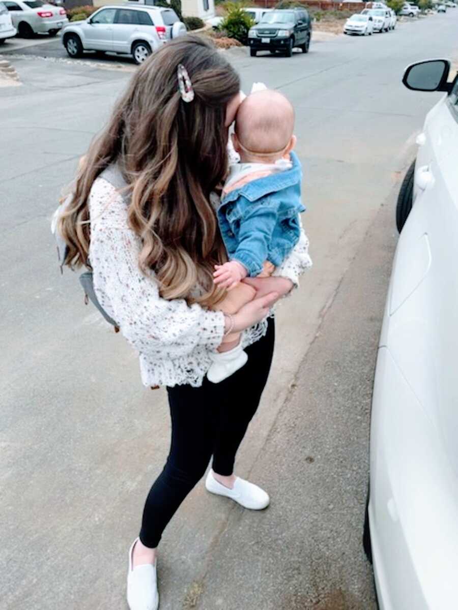 Mom holds her newborn daughter close in a sweet bonding moment