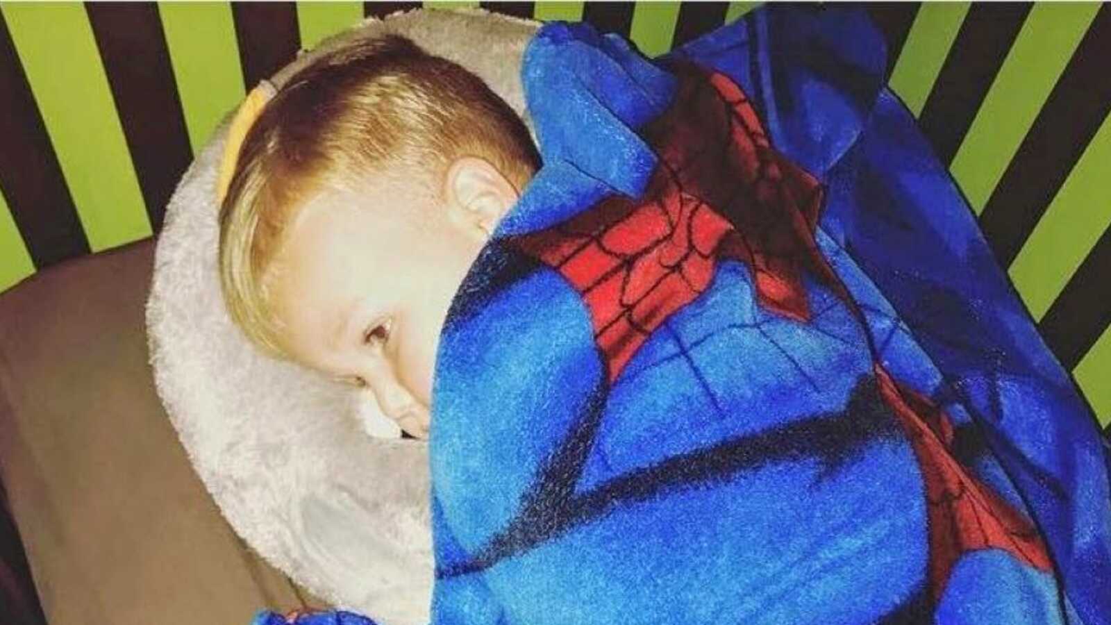 Mom snaps a photo of her son sleeping in his bed with a Spiderman blanket